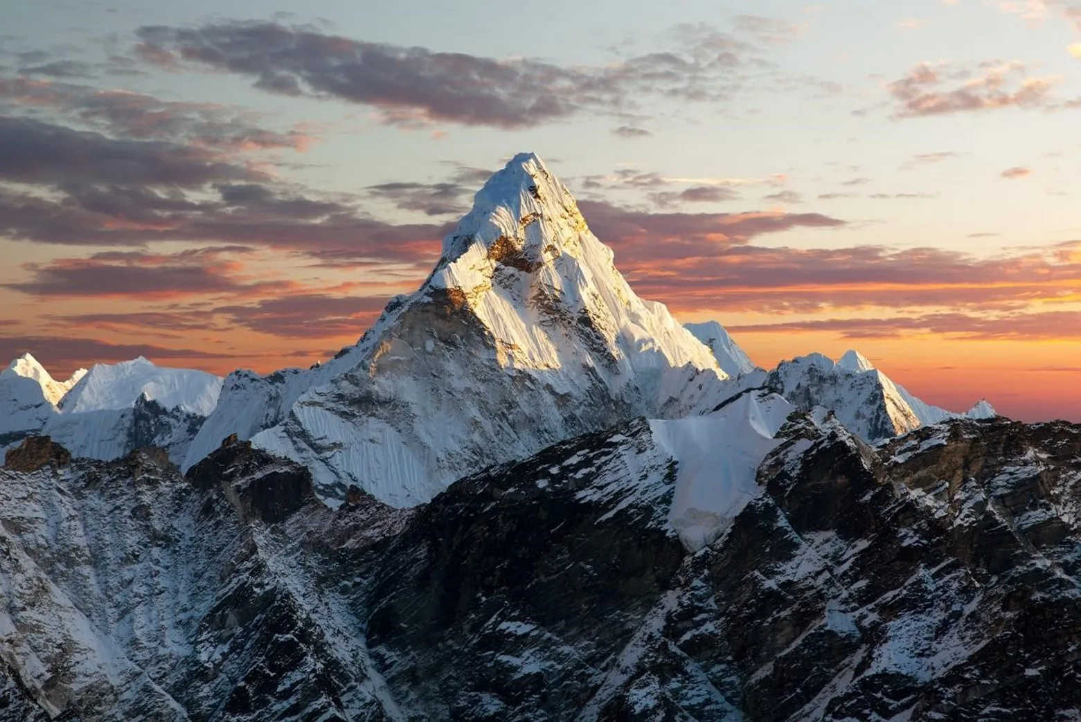dskl | Axxcess Platform Snowy, jagged mountain peak bathed in golden sunset light with a colorful sky
